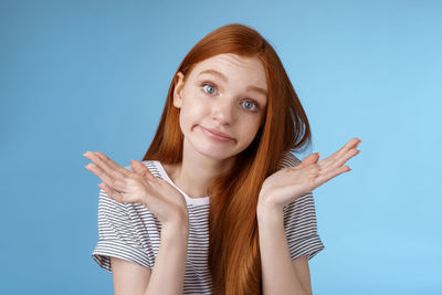 Redhead young woman against blue background