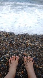 Low section of woman standing on beach