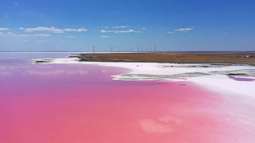 Aerial view of white salt on the shores of the island in pink island and blue sky . lake lemuria, 