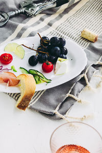 High angle view of grapes and cheese on table