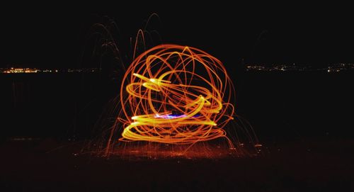 Illuminated light trails against sky at night