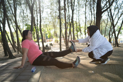 Side view of woman exercising on field