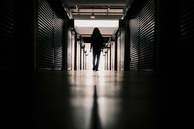 Low angle view of silhouette person standing in passage