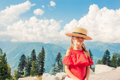 Portrait of woman wearing hat standing against sky