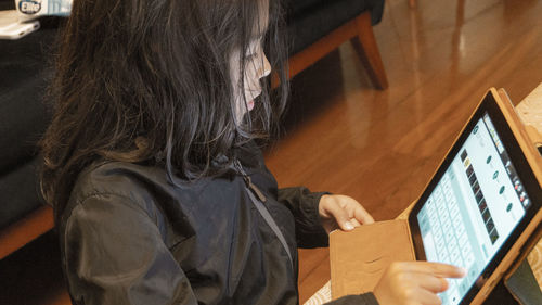 Midsection of woman using laptop at home