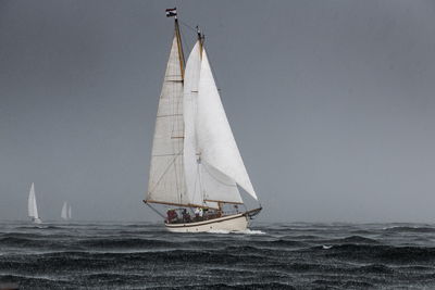 Sailboat sailing on sea against sky