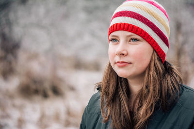 Portrait of a girl wearing a sriped hat in the winter