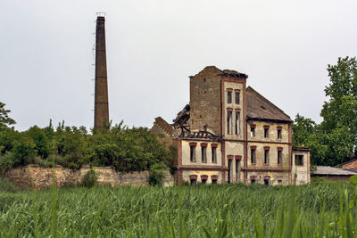 Old building in field against clear sky