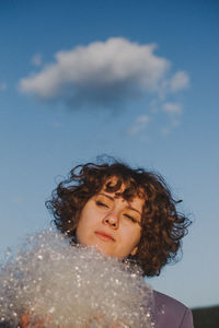 Woman with at plastic against blue sky