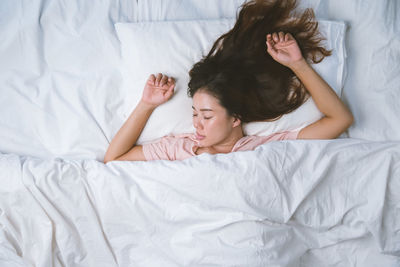 Directly above shot of young woman sleeping on bed