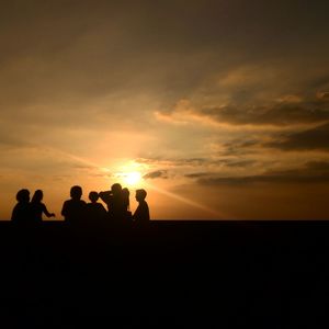 Silhouette people against sky during sunset