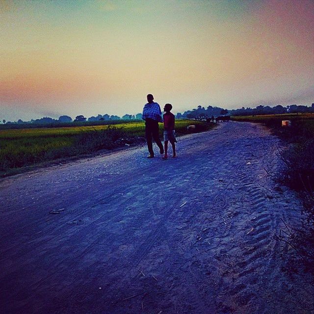 clear sky, full length, lifestyles, men, leisure activity, rear view, walking, togetherness, sunset, tranquility, tranquil scene, copy space, water, nature, landscape, scenics, beauty in nature, person