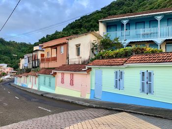 Houses by street against sky in city