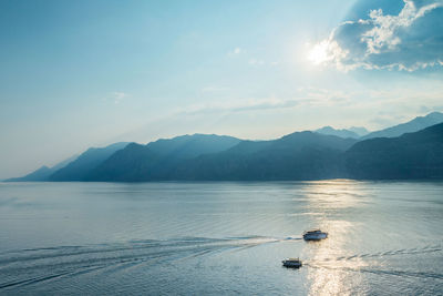 View of sea by mountains against sky