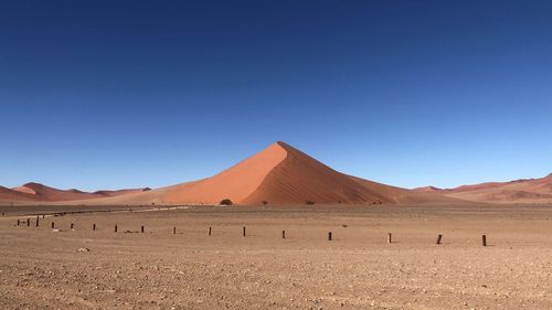 Scenic view of desert against clear blue sky