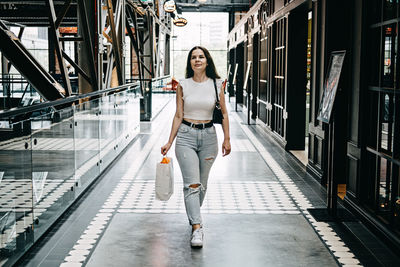 Modern latina young woman walking in large modern mall. young pretty brunette female consumer