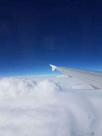 Airplane flying over cloudscape against blue sky