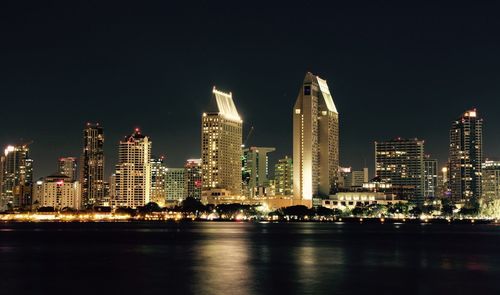 Illuminated cityscape against sky at night