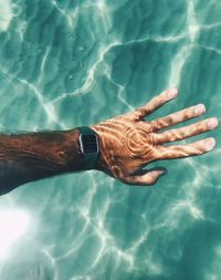 Cropped image of man wearing wristwatch in swimming pool