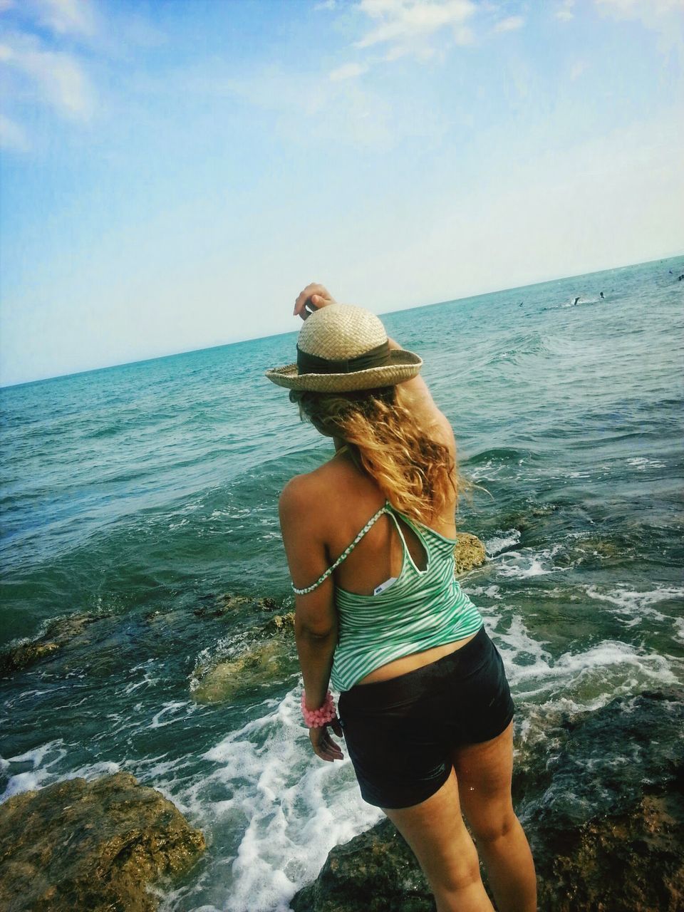 sea, water, lifestyles, sky, leisure activity, horizon over water, rear view, beauty in nature, nature, holding, scenics, tranquil scene, tranquility, young adult, beach, three quarter length, full length, casual clothing