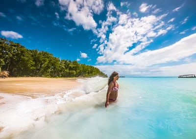 Woman in sea against sky