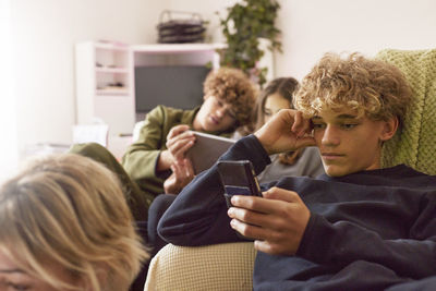Siblings using electronic devices at home
