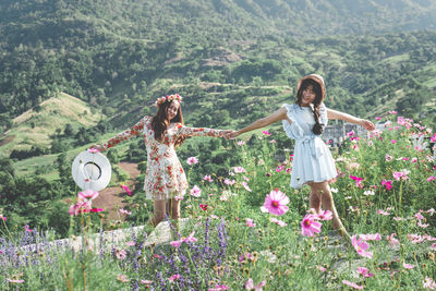 Rear view of women standing by flowering plants