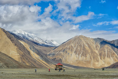 People on snowcapped mountains against sky