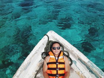 High angle portrait of young woman in sunglasses at sea