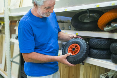 Man holding wheel while working in workshop