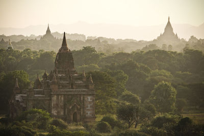 Historic temples by trees at bagan archaeological zone