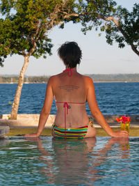 Rear view of woman standing in swimming pool