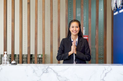 Portrait of a smiling young woman sitting on table