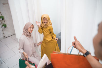 Man gesturing to mother and daughter at mall