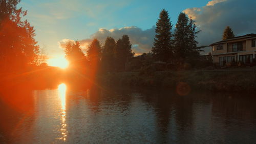 Reflection of trees in water at sunset