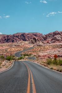 Road by mountain against sky