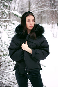 Portrait of young woman standing on snow