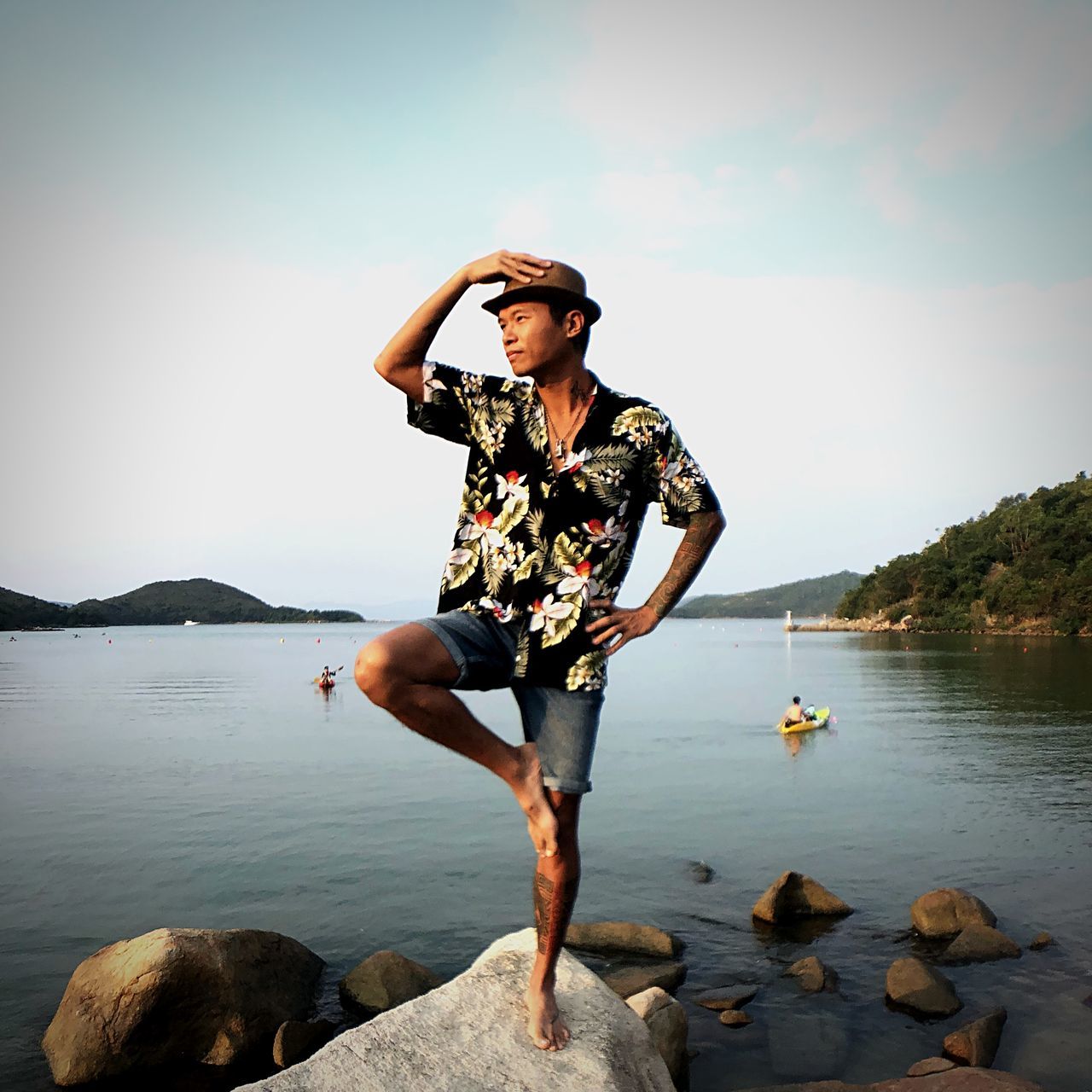 water, one person, sky, real people, lifestyles, rock, rock - object, solid, beauty in nature, leisure activity, young adult, sea, scenics - nature, full length, nature, casual clothing, day, standing, outdoors, shorts