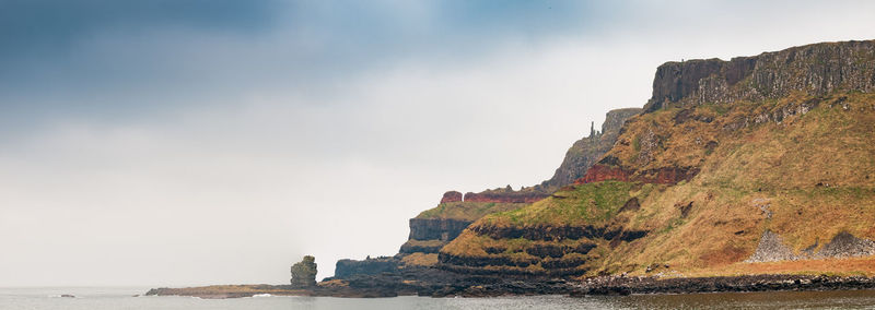 Rock formations by sea against sky