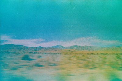 Scenic view of mountains against blue sky