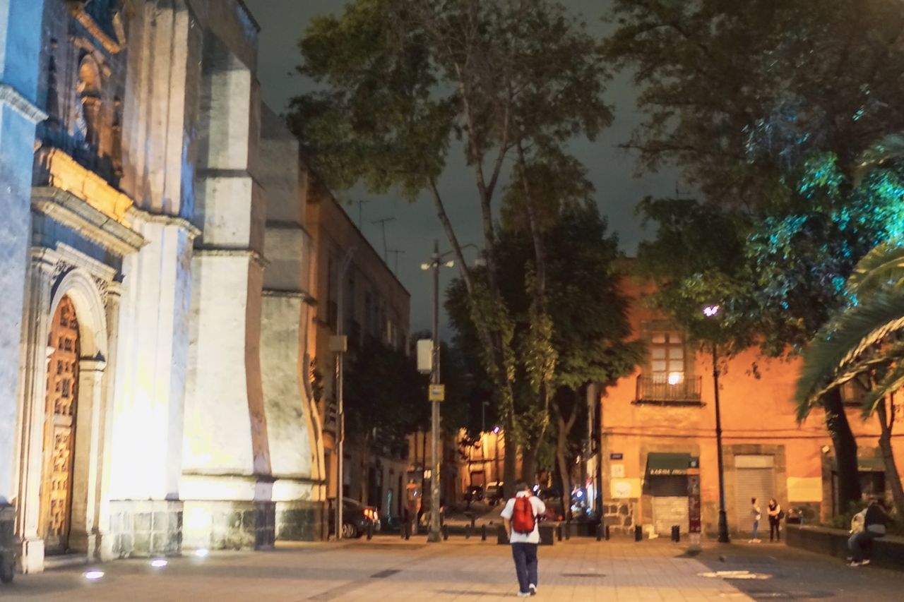 PEOPLE WALKING ON STREET AMIDST BUILDINGS