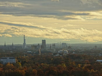 Cityscape by sea against sky during sunset