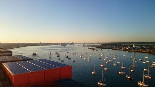 High angle view of sailboats moored in sea against clear sky