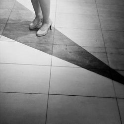 Low section of woman standing on tiled floor