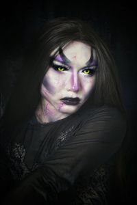 Close-up portrait of young woman in darkroom