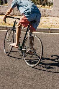 Low section of man riding bicycle on street