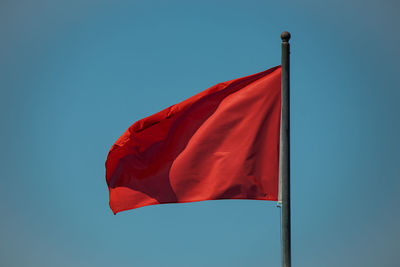 Low angle view of flag against blue sky