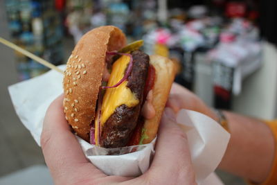 Cropped image of hand holding hamburger