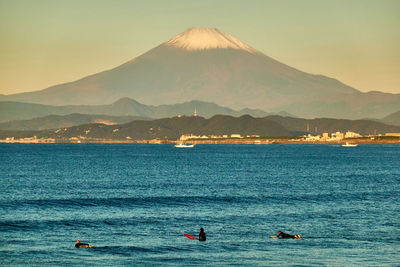 Scenic view of sea and mountains against sky during sunrise