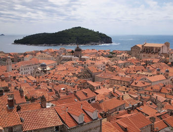 High angle view of cityscape by sea against sky